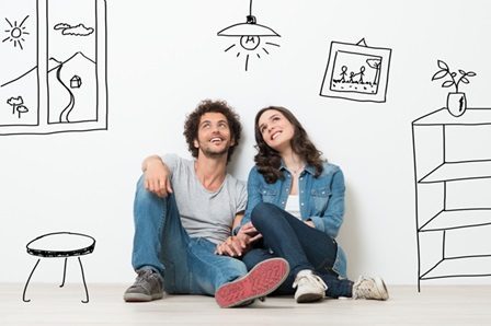 A man and a woman sitting on the floor dreaming about buying a property